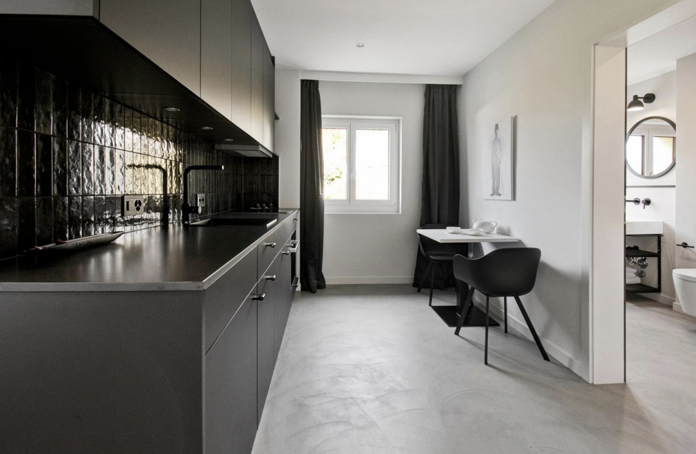 Eleganter Innenausbau mit dunkler Designküche und integrierter Sitzecke – Innenarchitektur mit Kontrastwirkung im Raum Zürich Eleganter Innenausbau mit dunkler Designküche und integrierter Sitzecke – Innenarchitektur mit Kontrastwirkung im Raum Zürich