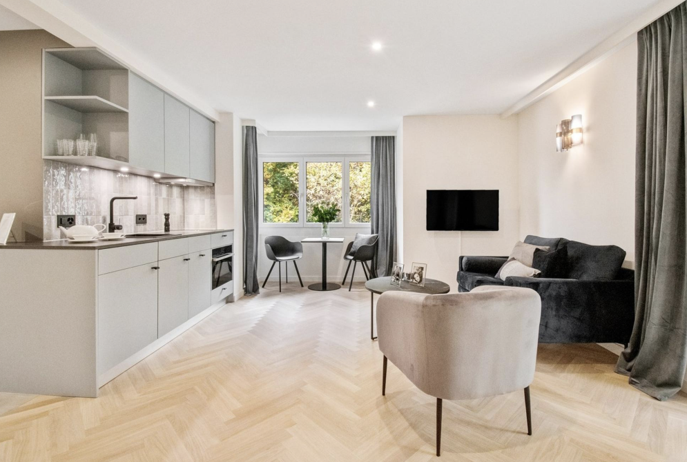 Wohnungsumbau mit Fischgrätparkett und moderner Küchenzeile in grau mit offenem Grundriss und Designerakzenten Wohnungsumbau mit Fischgrätparkett und moderner Küchenzeile in grau mit offenem Grundriss und Designerakzenten