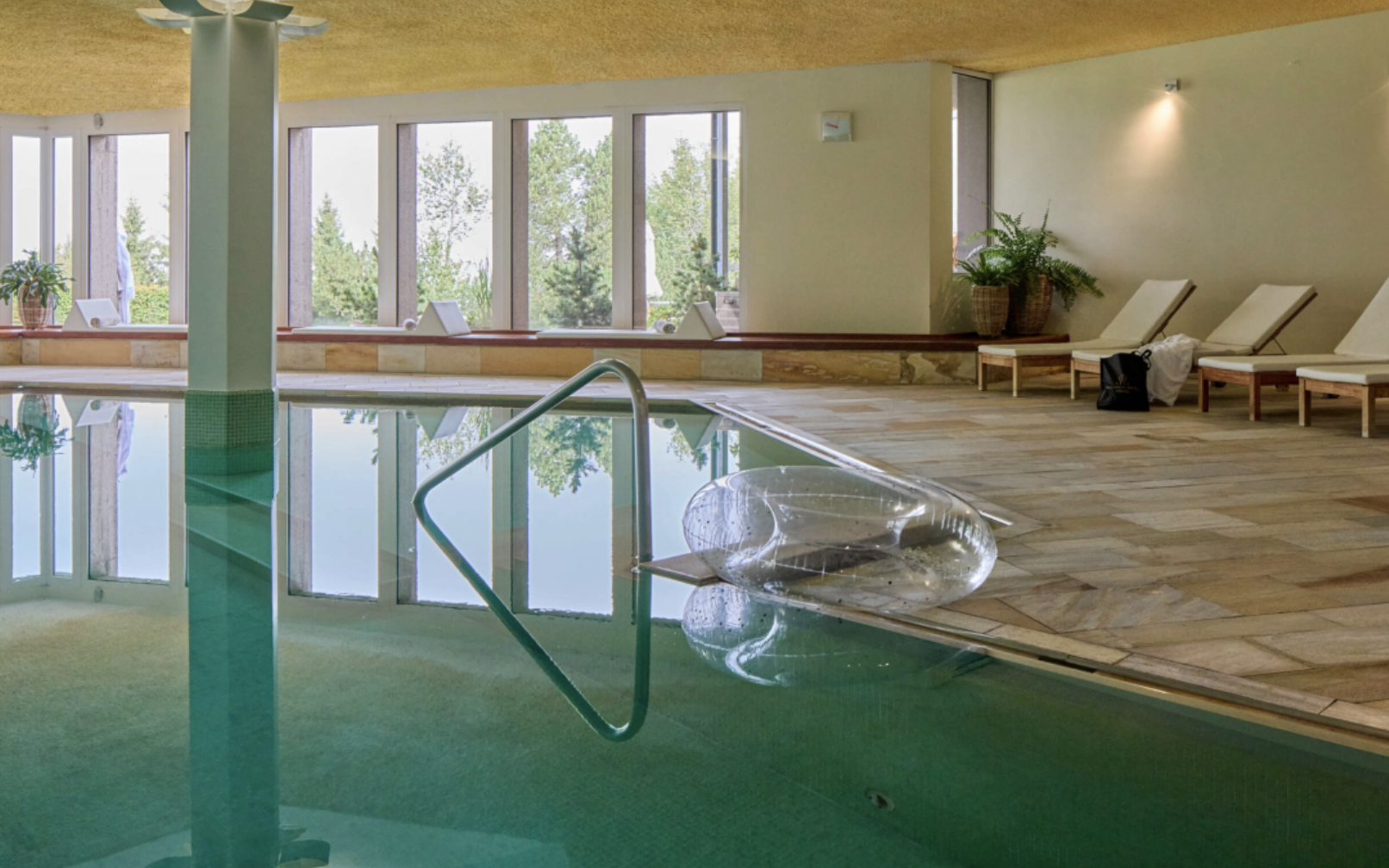 Wellnessbereich mit Indoorpool, Panoramafenstern und Natursteinboden – Wellnesshotel Stoos Wellnessbereich mit Indoorpool, Panoramafenstern und Natursteinboden – Wellnesshotel Stoos